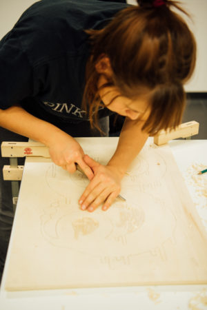 Teilnehmerin arbeitet an ihrem Holzschnitt