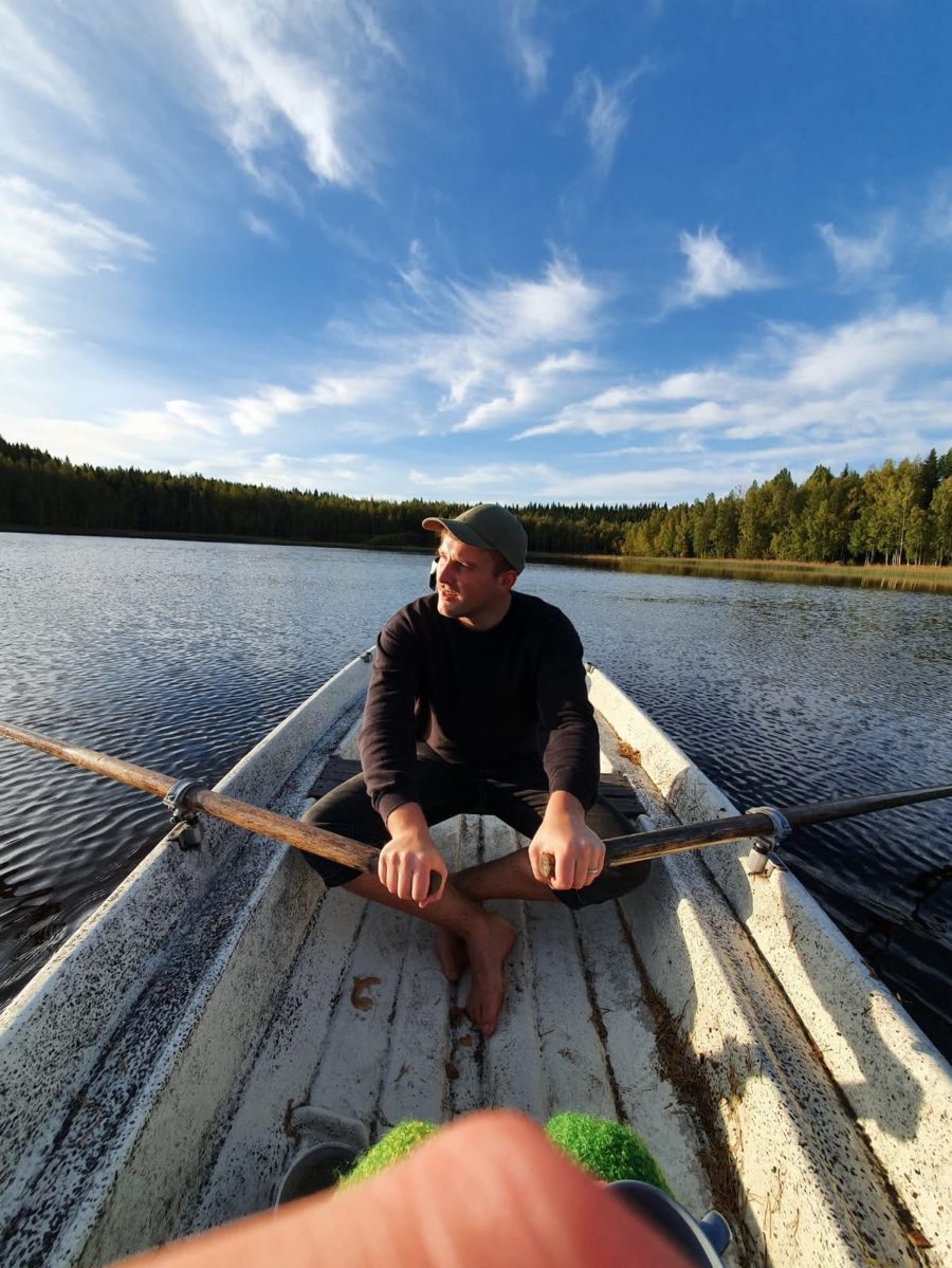Michael Buchta mit zwei Rudern in der Hand auf einem Boot auf einem See