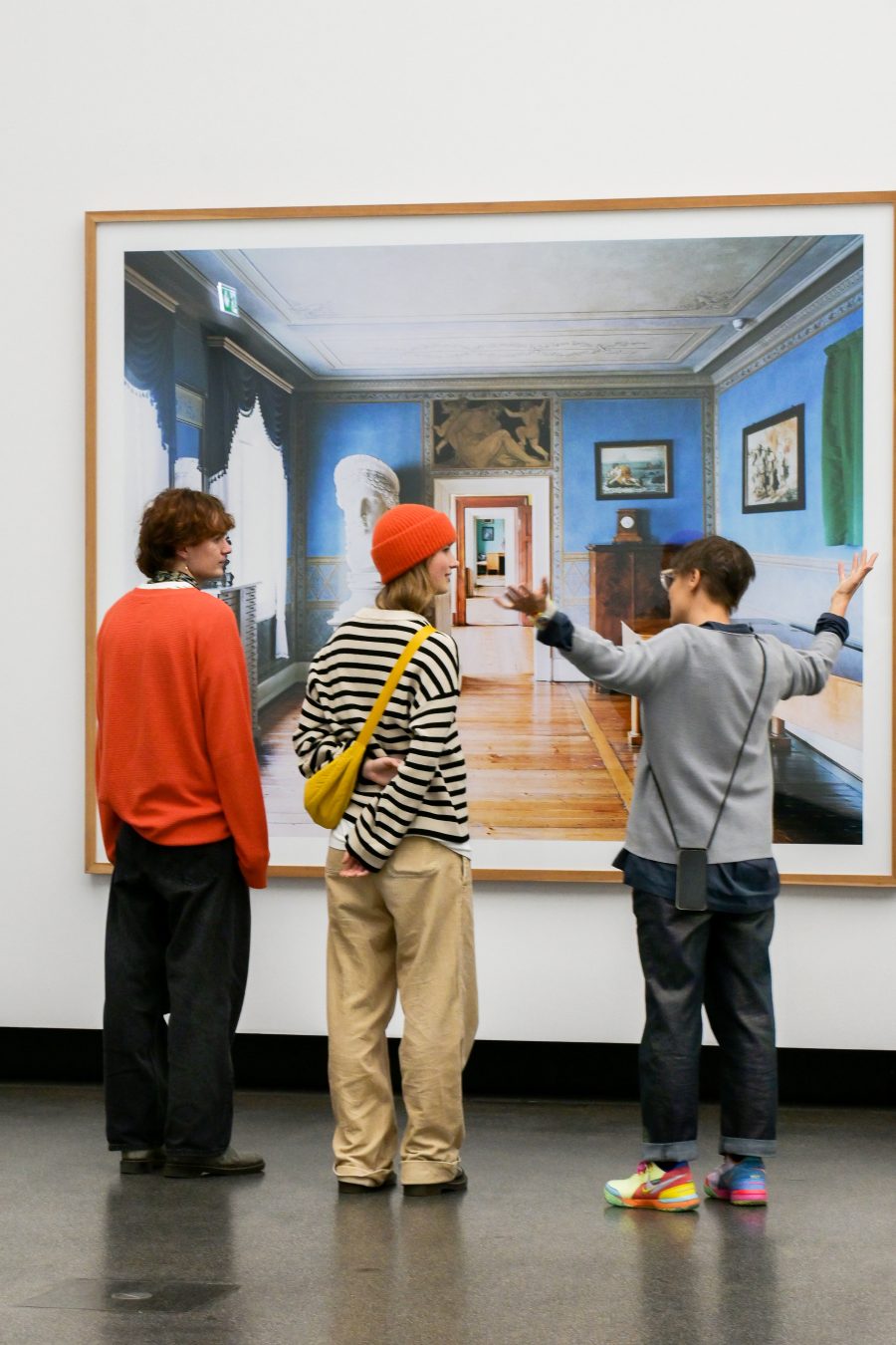 Zwei Studierende stehen mit Prof. Diehl vor einer Fotografie in einem Museum